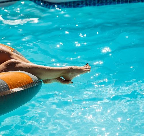 mulher relaxando em boia na piscina