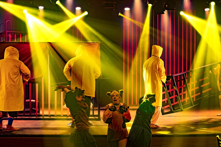 pessoas correndo na frente do palco e iluminação amarela