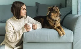 mulher tomando chá com cachorro do lado