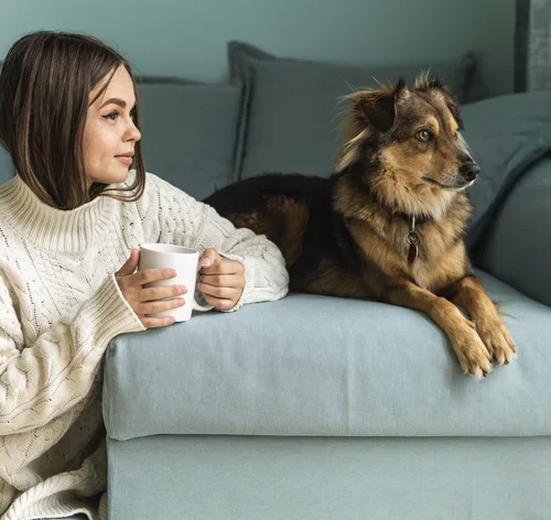 mulher tomando chá com cachorro do lado